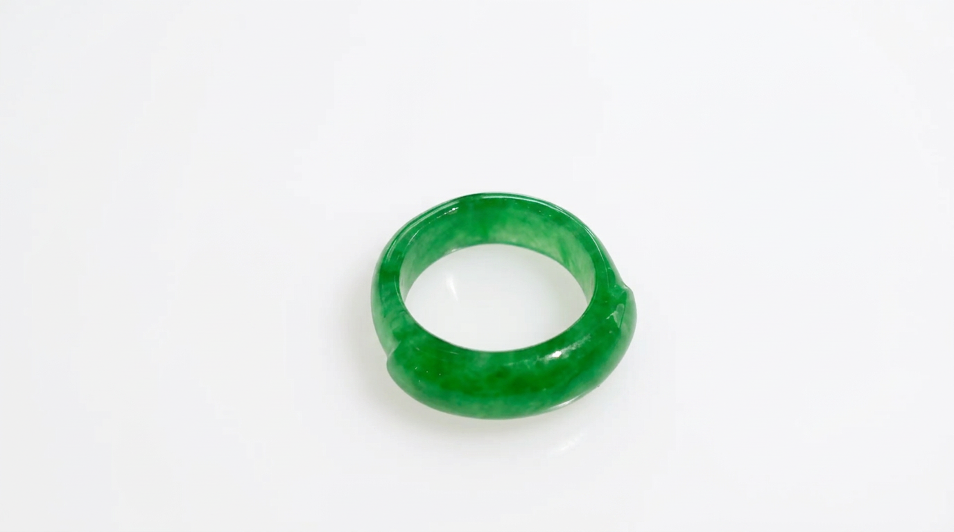 Solid jade ring in deep green on a white background